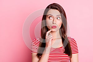 Photo of minded stunning creative young woman look empty space hold finger chin isolated on pink color background