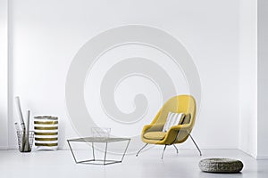 photo of a minimalistic living room interior with a yellow armchair. Empty, white wall. Place your poster