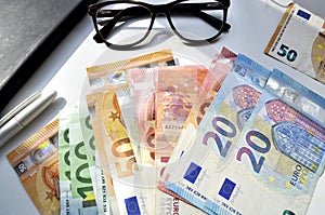 Photo of money, paper bills lying on the table. Bright image of money, euros in sunlight. photo