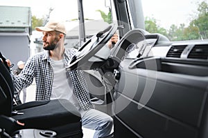 Photo of motivated truck driver entering his semi truck long vehicle. Happy trucker. Transportation service