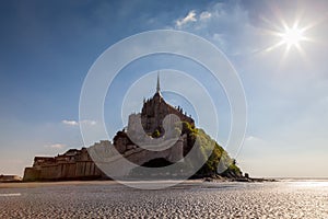 Photo of Mt St Michel in Normandy France in the afternoon with a sunstar