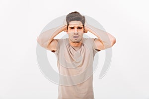 Photo of muscular adult man 30s grabbing his head or covering ea