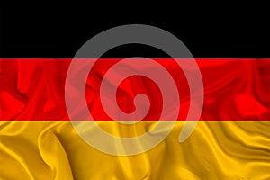 Photo of the national flag of Germany on a luxurious texture of satin, silk with waves, folds and highlights, close-up, copy space