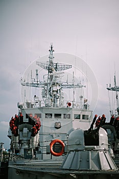 Photo of a naval warship docked at the pier, showcasing military power and readiness