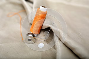 Photo of needle attached in cloth with Orange Sewing thread and bobbin