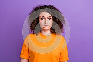 Photo of nervous uncertain woman wear orange t-shirt biting lip feeling guilty isolated purple color background