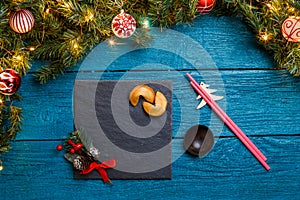 Photo of New Year branches of fir, black board, sticks for sushi, cookies with prediction