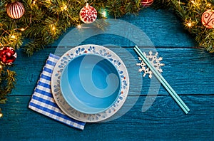 Photo of New Year branches of fir, cookies with prediction, plates, sticks for sushi, snowflakes, napkin