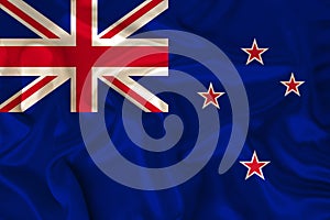 Photo of the New Zealand state national flag on a luxurious texture of satin, silk with waves, folds and highlights, close-up,