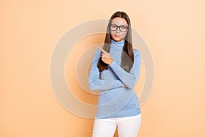 Photo of nice brunette young lady show empty space wear eyewear blue pullover isolated on beige color background