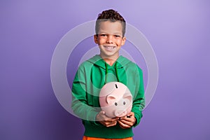 Photo of nice cute latin rich boy wear green stylish clothes hold piggy bank financial future isolated on purple color