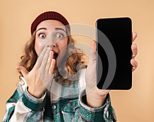 Photo of nice delighted woman showing cellphone and expressing surprised