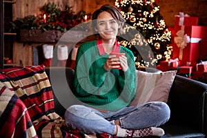 Photo of nice milennial brunette lady sit drink wear green sweater jeans socks at home on holiday