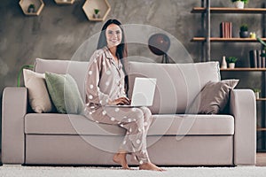 Photo of nice optimistic girl sit write laptop wear spectacles pijama at home on sofa photo