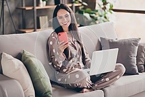 Photo of nice optimistic girl sit write telephone hold laptop wear pijama at home