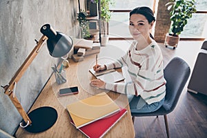 Photo of nice positive author lady sit table write report wear striped sweater in comfortable apartment home indoors