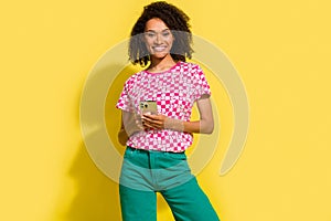 Photo of nice positive girl hold smart phone chatting telegram facebook instagram isolated on yellow color background