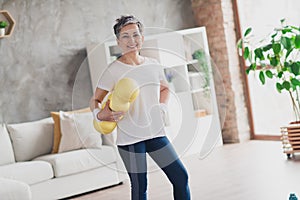 Photo of nice retired woman hold massage roll sportswear sport healthy lifestyle workout modern apartment home living