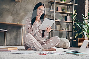 Photo of nice sweet girl sit on carpet hand face type tablet wear spectacles pijama at home photo