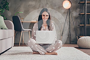 Photo of nice sweet girl sit on carpet type laptop wear spectacles pijama at home photo