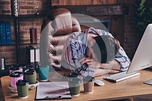 Photo of nice young corporate man sit chair sleep desk wear striped shirt loft interior office indoors