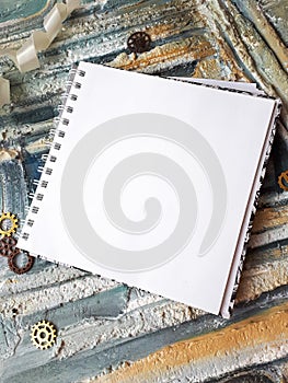 Photo of notepad against the background of a relief wall with decorative elements