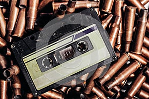 Photo of an old audio tape cassette on pile of bullets