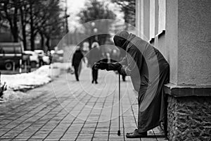 Photo of old hungry homeless female beggar beg for alms and on street.