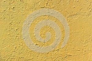 Photo of an old weathered concrete wall tinted yellow to use as a background