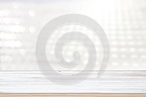 Photo of old wooden table in front of white and silver glitter lights background. Ready for product display montage