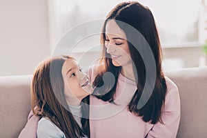 Photo of optimistic brunette red hairdo mom daughter hug sit on sofa wear sweater at home