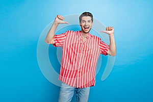 Photo of optimistic confident perky man with bristle dressed striped shirt indicating at himself isolated on blue color