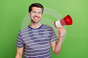 Photo of optimistic satisfied young marketolog promoter activist guy need attention hold loudspeaker isolated on green