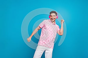 Photo of overjoyed carefree person enjoy favorite music headphones dancing chilling isolated on blue color background