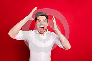 Photo of overjoyed happy screaming shouting man fortunate champion being isolated with red background