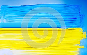 Photo of painting Ukraine flag on window. Ukraine flag brush concept. Color image of flag of Ukraine on glass with paints. Banner