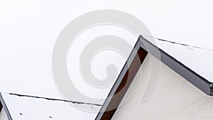 Photo Panorama frame Home exterior with close up view of the gable roof covered with sheet of snow