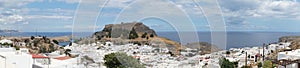 Photo panorama. View of the white buildings of Captains houses of the 16th-18th centuries and the ancient Acropolis of Lindos