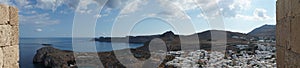 Photo panorama. View of the white houses of the 16th-18th centuries from the ancient Acropolis of Lindos in August.