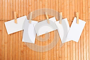 Photo paper attach to rope with clothes pins on wooden background - Image