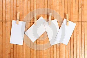 Photo paper attach to rope with clothes pins on wooden background - Image