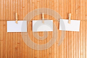 Photo paper attach to rope with clothes pins on wooden background - Image