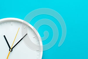 Photo of part of white wall clock over turquiose blue background with copy space