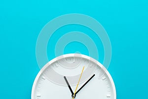 Photo of part of white wall clock over turquiose blue background with copy space