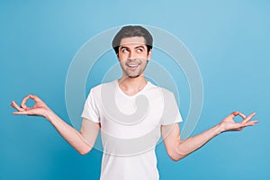 Photo of peaceful serene man meditate look empty space wear white t-shirt isolated blue color background