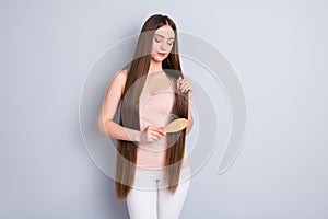 Photo of perfect appearance model lady long hairdo hold favorite wooden comb brushing strong curls wear beige singlet