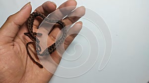 a photo of a person holding a heart-shaped brown bracelet