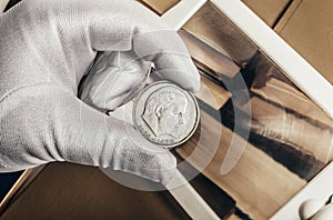 Photo of a person's hand in gloves holding a soviet ruble coin