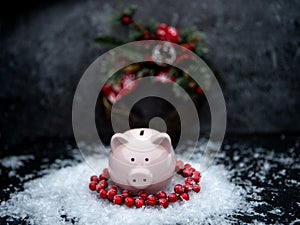 Photo of piggy bank with Christmas decoration on black table