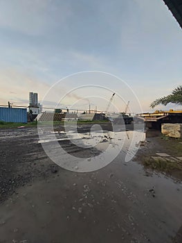 photo of pile factory with muddy soil in front of the camera